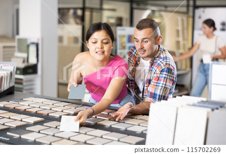 Couple man and woman choosing tile samples in store Couple man and woman choosing tile samples in store 115702269