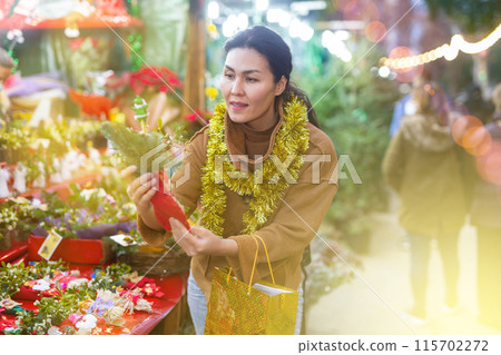 Woman choosing christmas decoration at street sale 115702272