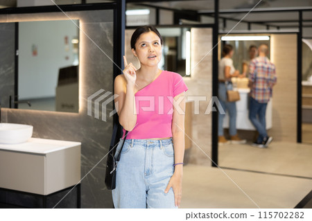 Young asian girl in hardware store choosing bathroom accessories 115702282