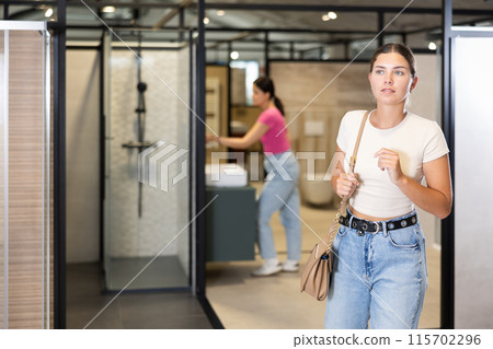 Female shopper exploring bathroom fixtures in home improvement store Female shopper exploring bathroom fixtures in home improvement store 115702296