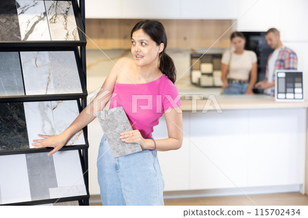 Asian woman browsing tile samples in home improvement store Asian woman browsing tile samples in home improvement store 115702434