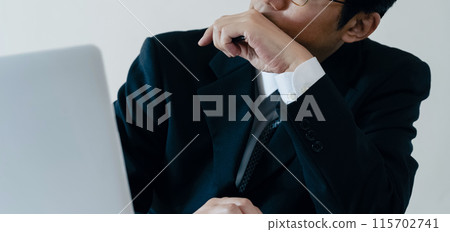 A businessman worried in front of a computer A businessman worried in front of a computer 115702741