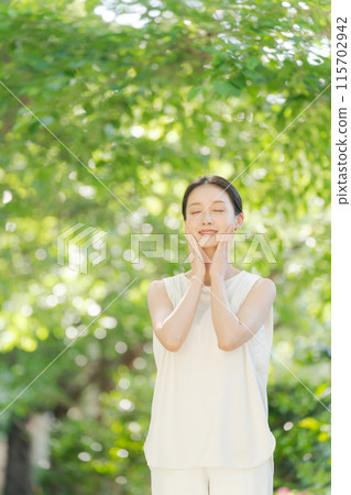 一個女人在綠樹中微笑的美麗 115702942