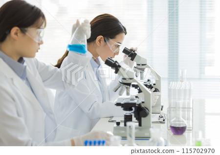 Woman in a white coat doing research Experiment Microscope 115702970