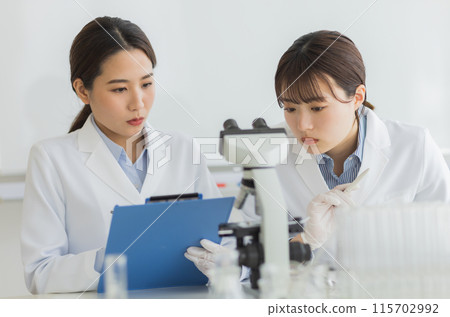 Woman in a white coat doing research Experiment Microscope 115702992