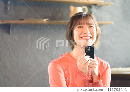 A woman watching a smartphone at a cafe A woman watching a smartphone at a cafe 115703441