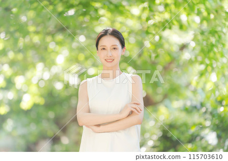 一個20多歲的女人在新鮮的綠色植物中微笑 一個20多歲的女人在新鮮的綠色植物中微笑 115703610