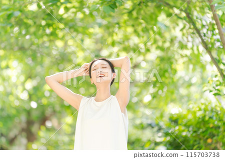 A woman taking a deep breath in the greenery 115703738