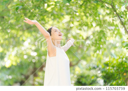 A woman taking a deep breath in the greenery 115703739