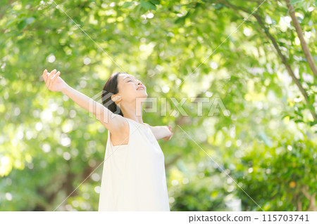 A woman taking a deep breath in the greenery 115703741
