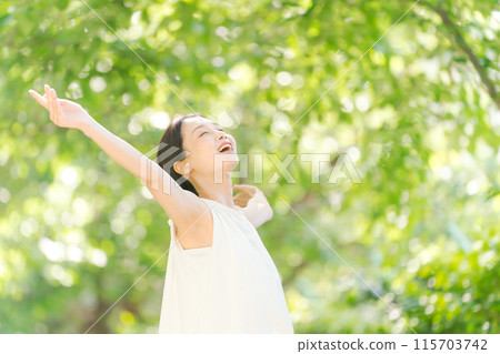 A woman taking a deep breath in the greenery 115703742