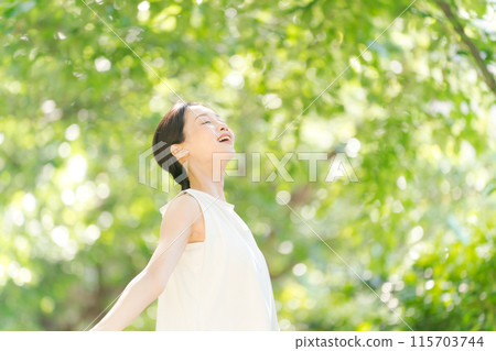 A woman taking a deep breath in the greenery 115703744