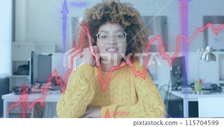 Blue and red graphs and arrows over biracial casual businesswomen having image call in office 115704599