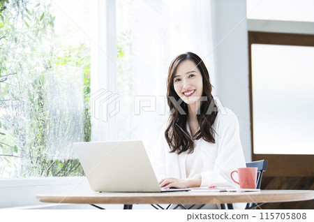 Young woman teleworking in a cafe 115705808