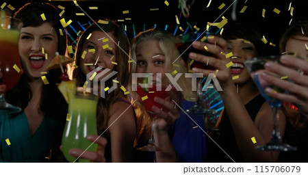 Diverse female friends celebrate with drinks in a club as gold confetti falls. Diverse female friends celebrate with drinks in a club as gold confetti falls. 115706079