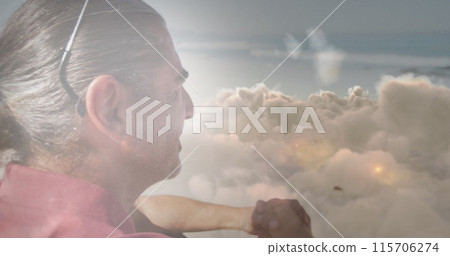 Image of glowing lights over senior man and clouds background 115706274