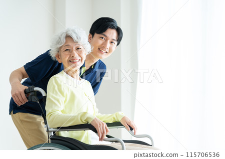 Senior woman in a wheelchair and a young caregiver 115706536