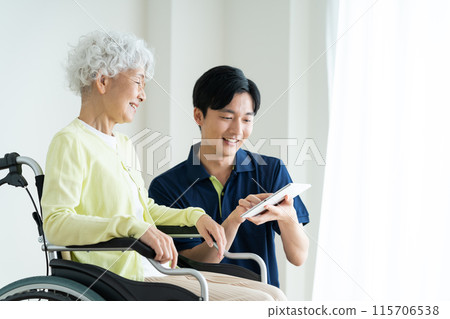 Senior woman in a wheelchair and a young caregiver 115706538