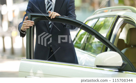 A young man in a suit driving A young man in a suit driving 115708344