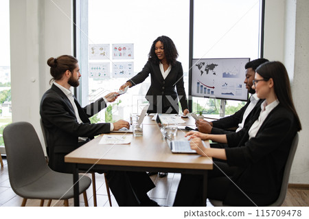 Businesswoman giving money during meeting in modern office 115709478