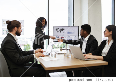 Businesswoman giving money during meeting in modern office 115709505