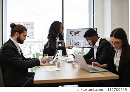 Business meeting with diverse team discussing financial charts 115709519