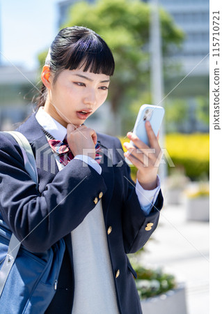 A high school girl with a smartphone 115710721