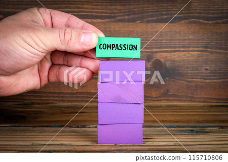 Compassion Concept. Purple blocks in a pile on a wooden texture background Compassion Concept. Purple blocks in a pile on a wooden texture background 115710806