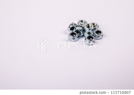 Bunch of zinc plated self locking hexagon nuts on white background, place for text Bunch of zinc plated self locking hexagon nuts on white background, place for text 115710807