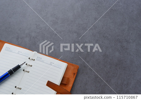 Image of a ring-type system organizer being opened and writing a diary Image of a ring-type system organizer being opened and writing a diary 115710867