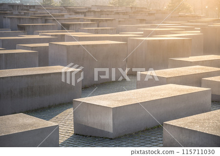 Warm sunset light casting shadows over the stelae of the Holocaust Memorial in Berlin. Germany 115711030