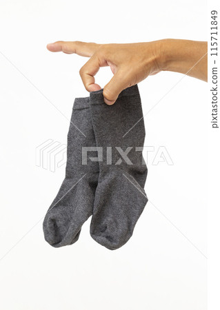 Hands holding socks on white background 115711849