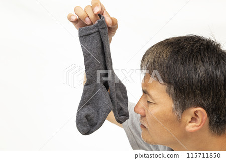 Man holding socks on white background 115711850