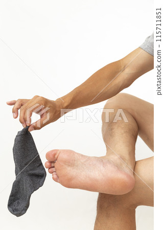 Man holding socks on white background 115711851