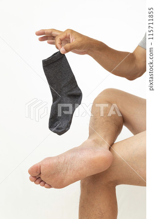 Man holding socks on white background 115711855