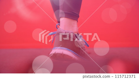 Image of light spots over caucasian woman walking on red background 115712371