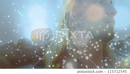 Glowing spots of light against caucasian man walking on the rocks near the sea 115712545