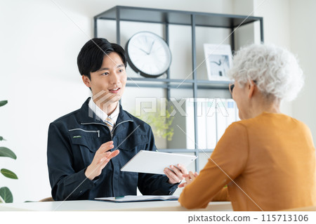 A young man in a construction company selling to a senior woman 115713106