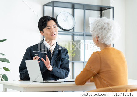 建築公司的一名年輕男子向年長女性銷售產品 建築公司的一名年輕男子向年長女性銷售產品 115713113