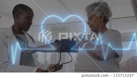 Image of cardiograph and heart over diverse senior female patient and doctor taking pressure 115713287