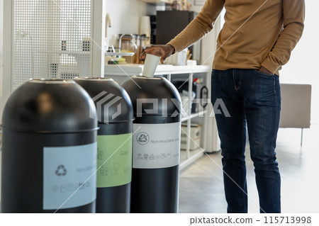 Waste separation and recycling, man throwing out paper cup into bin Waste separation and recycling, man throwing out paper cup into bin 115713998