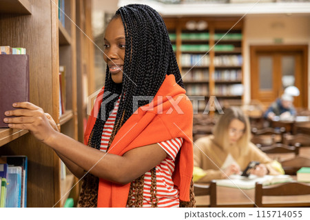 Long-haired young african american woman in the library 115714055