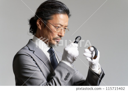 男鑑定員用放大鏡檢查手錶 男鑑定員用放大鏡檢查手錶 115715402