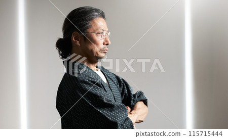 A man in a work uniform with his arms folded, senior craftsman image 115715444