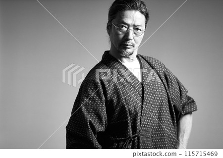 A man in a work uniform looking at something, senior craftsman, monochrome image A man in a work uniform looking at something, senior craftsman, monochrome image 115715469