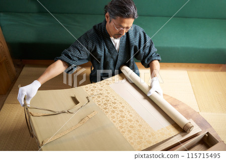 A man in a kimono spreading out a hanging scroll to check it - Appraiser, antique dealer, collector - Image A man in a kimono spreading out a hanging scroll to check it - Appraiser, antique dealer, collector - Image 115715495