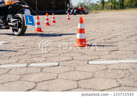 Riding between cones, lesson in motorcycle school. Close up. Letter L sign. Moto school track driving school. Riding between cones, lesson in motorcycle school. Close up. Letter L sign. Moto school track driving school. 115715593
