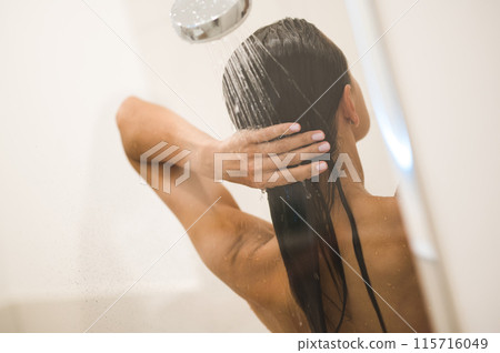 Dark-haired woman taking a shower and looking relaxed Dark-haired woman taking a shower and looking relaxed 115716049