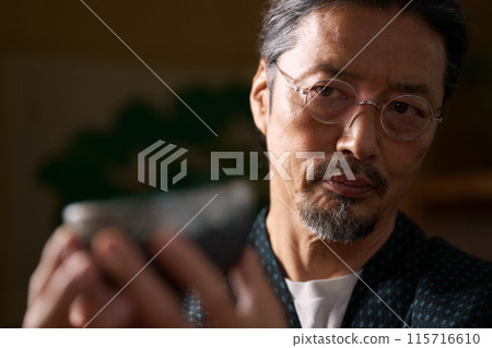 一個穿著日本服裝的男人看著陶瓷、陶藝家、鑑賞家的形象 一個穿著日本服裝的男人看著陶瓷、陶藝家、鑑賞家的形象 115716610