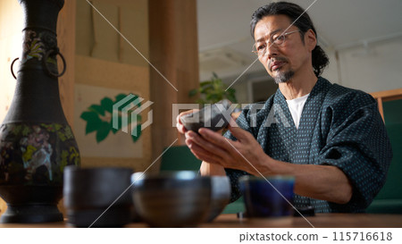 一個穿著日式服裝的男人看著陶瓷、陶藝家、鑑定師的形象 115716618